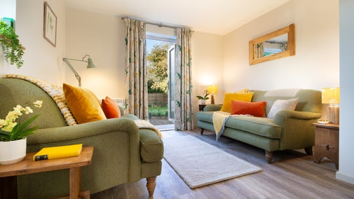 The sitting room at Cladium, showing the two sofas, and glass doors to the back garden, Cambridgeshire